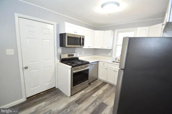 a kitchen with a refrigerator stove and white cabinets