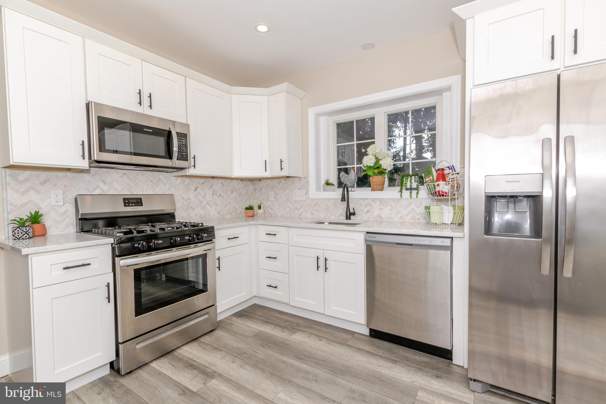 100 North 1st Road Hammonton, NJ 08037 - Photo 4 of 47 a kitchen with stainless steel appliances white cabinets a sink a stove a refrigerator and a microwave
