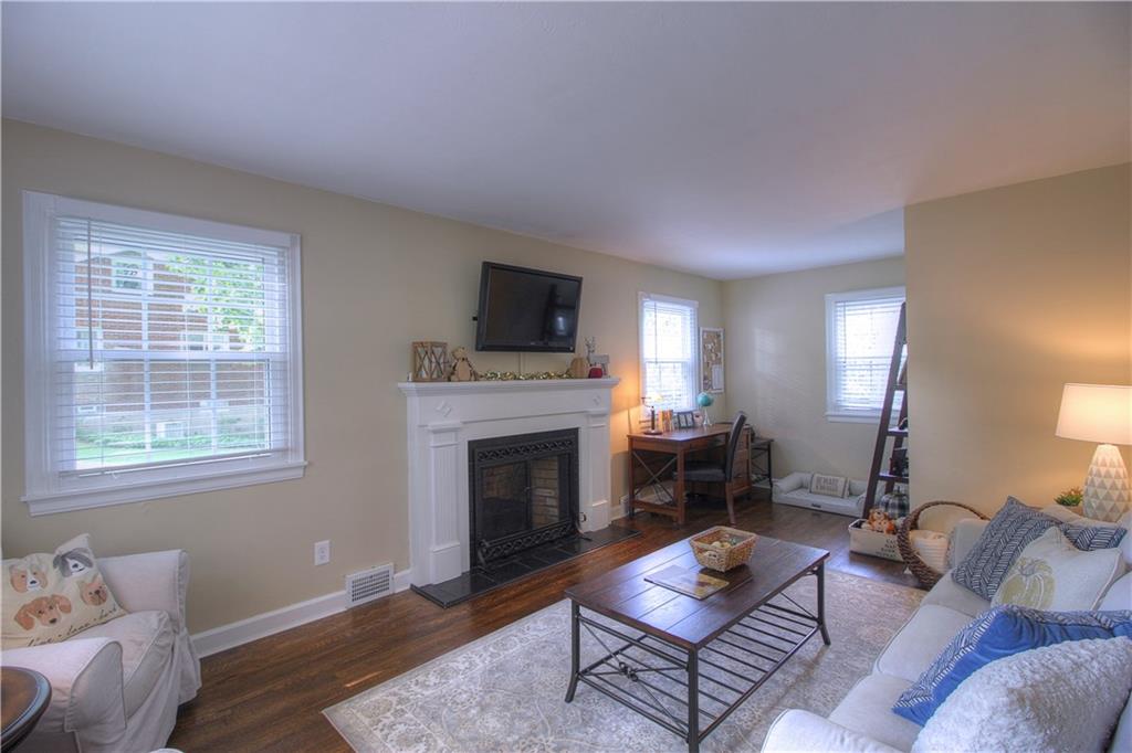 140 Oakville Road Beaver Falls, PA 15010 - Photo 11 of 25 Larger than it appears, the Living Room boasts an original woodburning fireplace, refinished hardwood flooring and a perfect flex space in the background for desk, play....
