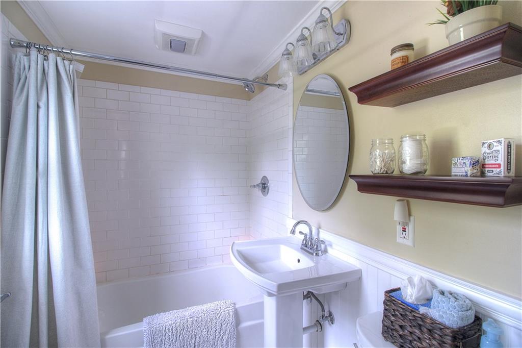 140 Oakville Road Beaver Falls, PA 15010 - Photo 21 of 25 Keeping with the character of the home, the owners selected subway tile and a pedestal sink to complement the wainscoting and crown molding. New tub and commode as well!