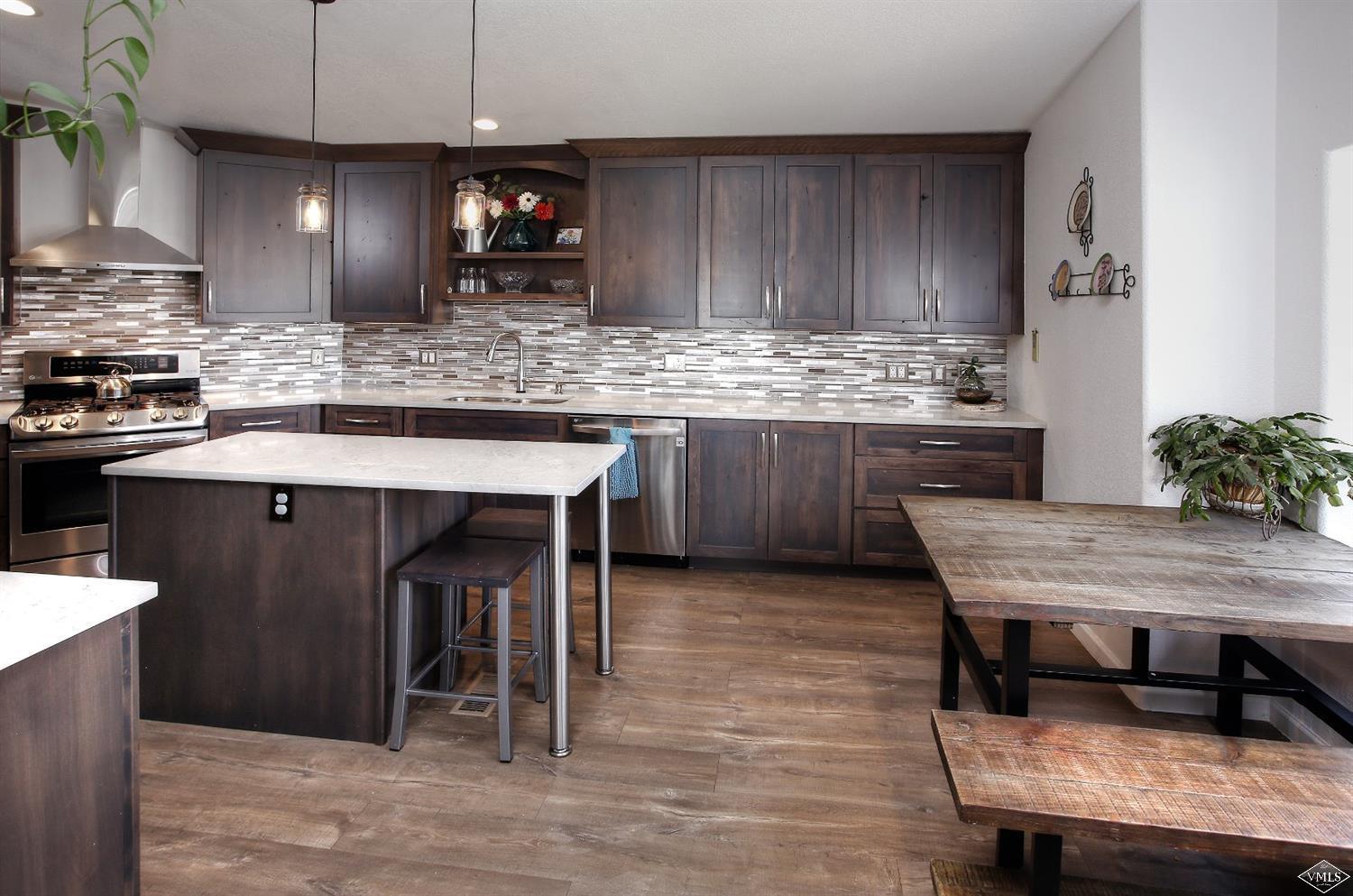 134 Ringneck Eagle, CO 81631 - Photo 10 of 25 a kitchen with stainless steel appliances kitchen island granite countertop a table chairs sink and cabinets