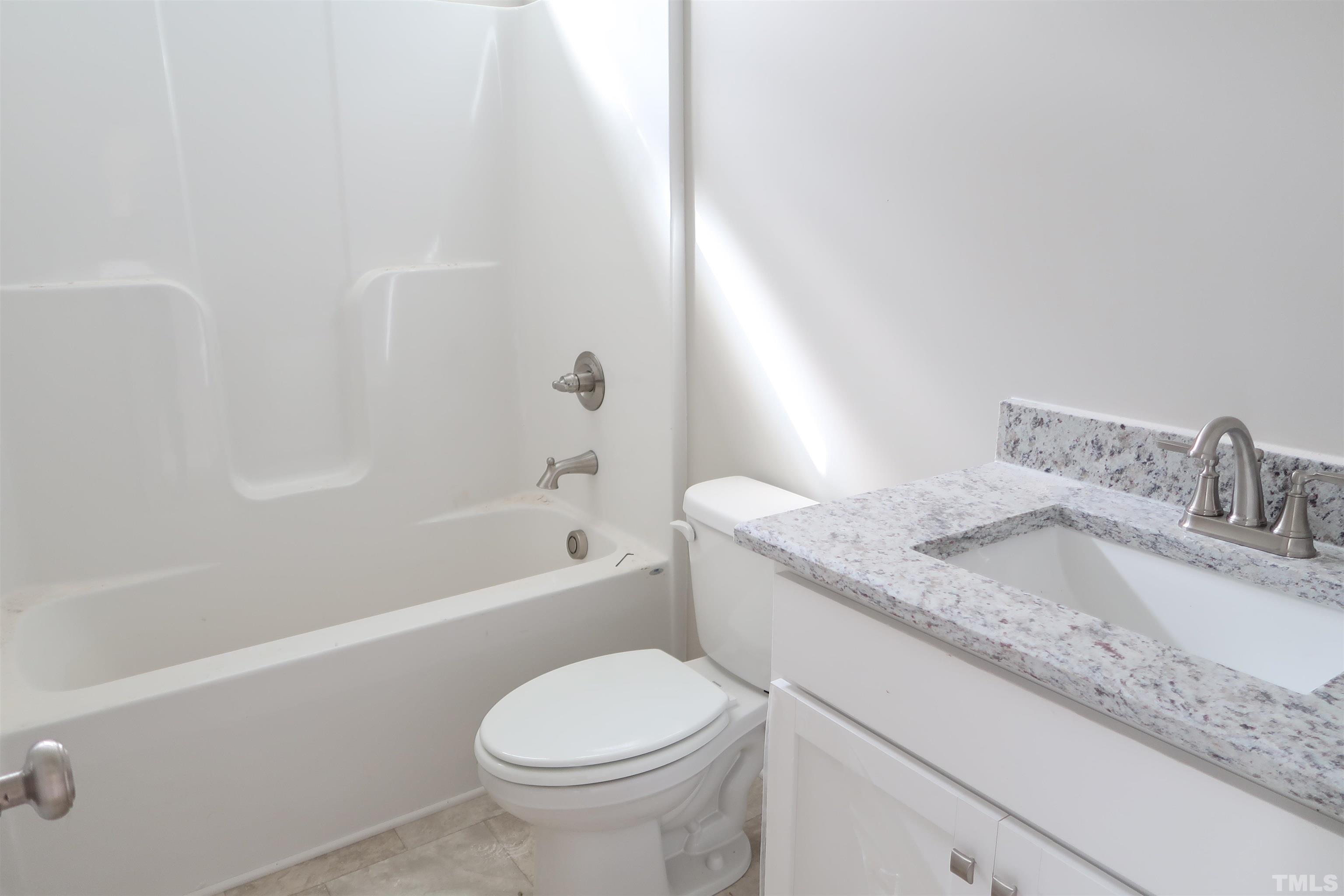 1191 Denning Road Angier, NC 27501 - Photo 16 of 25 a bathroom with a granite countertop sink toilet and bathtub