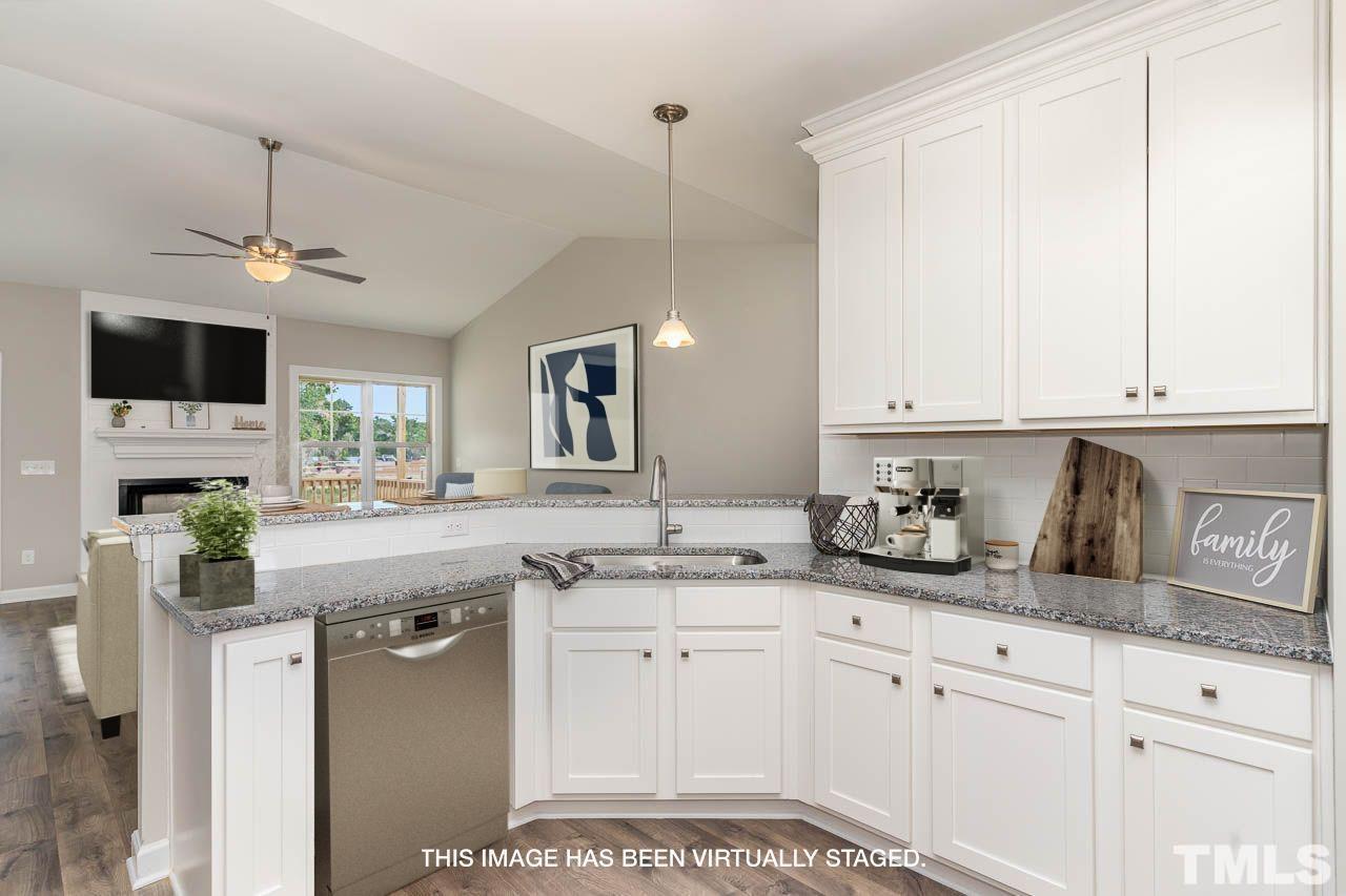 1191 Denning Road Angier, NC 27501 - Photo 20 of 25 a kitchen with granite countertop a sink stainless steel appliances and white cabinets