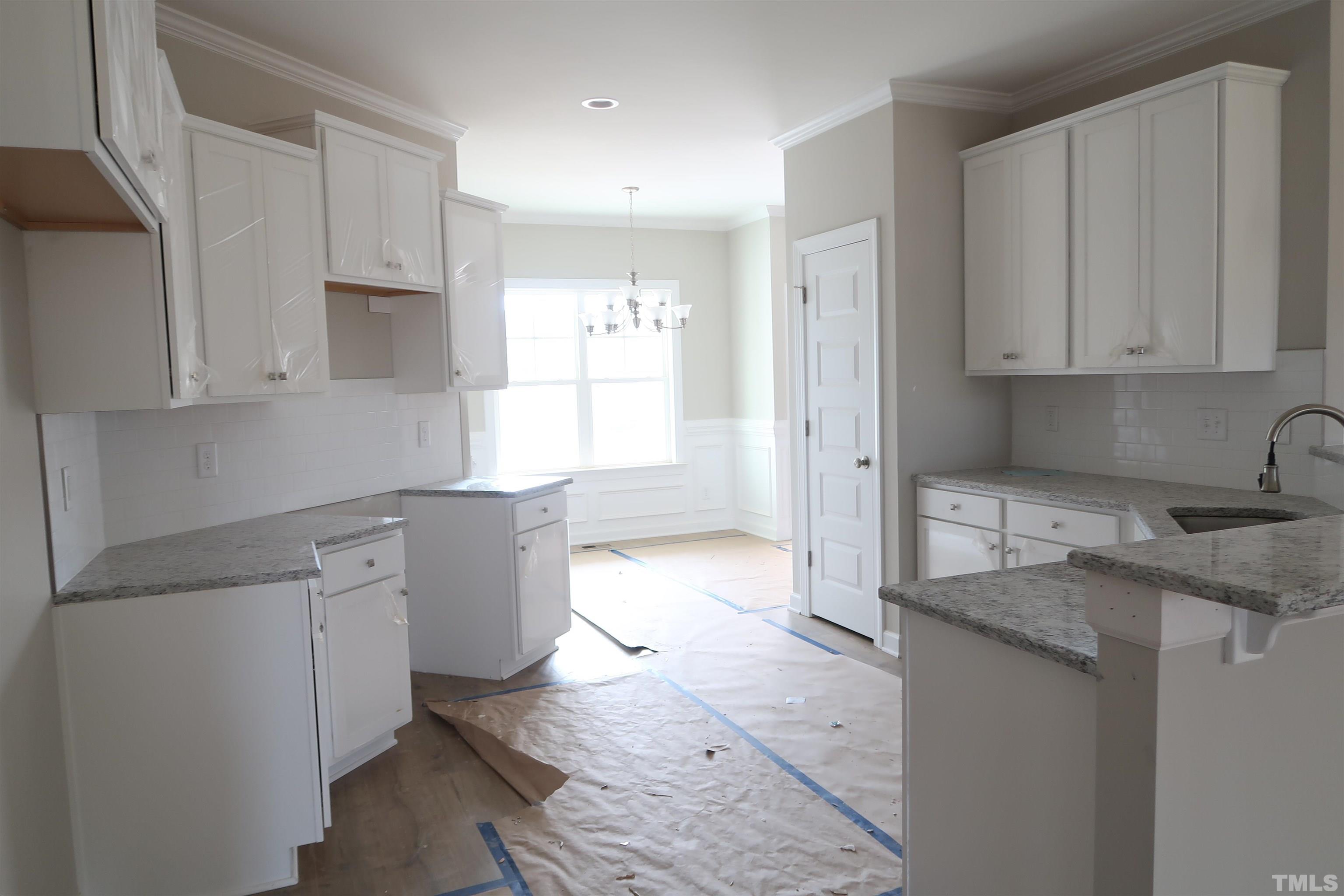 1191 Denning Road Angier, NC 27501 - Photo 8 of 25 a kitchen with granite countertop a sink stove and cabinets
