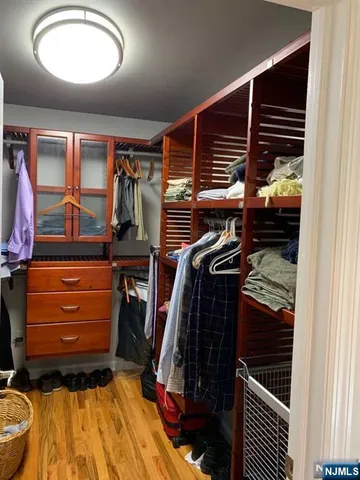 a view of walk in closet with clothes and shoes