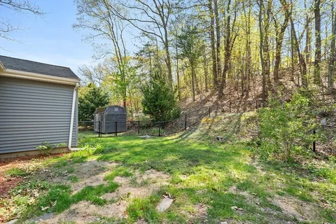 a backyard of a house with lots of green space and chair