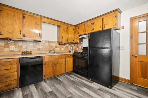 a kitchen with stainless steel appliances granite countertop a refrigerator a sink and dishwasher with wooden floor