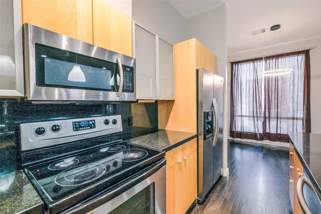 a kitchen with stainless steel appliances granite countertop a stove and a microwave