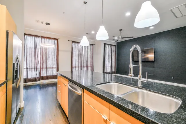 a kitchen with granite countertop a sink a counter top space and stainless steel appliances