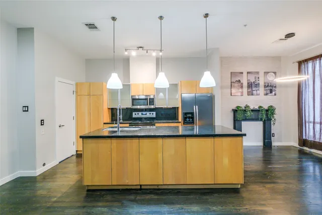 a kitchen with stainless steel appliances granite countertop a refrigerator a sink and a stove