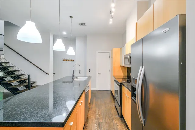 a open kitchen with stainless steel appliances granite countertop a sink and refrigerator