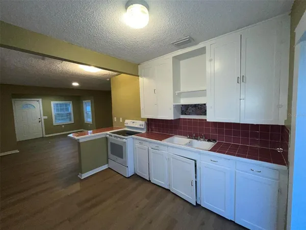 a view of empty room with wooden floor and window
