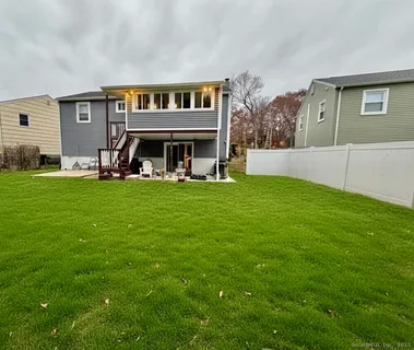 a view of a house with a big yard and large trees