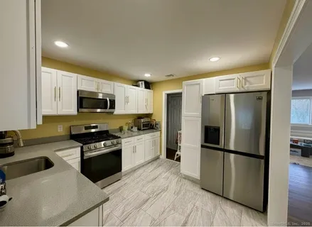 a kitchen with stainless steel appliances granite countertop a refrigerator a stove microwave and sink