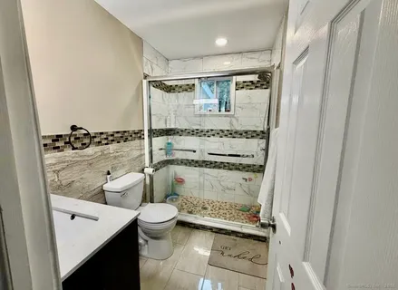 a bathroom with a granite countertop sink toilet and shower