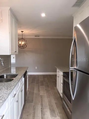 a kitchen with granite countertop a refrigerator and a sink