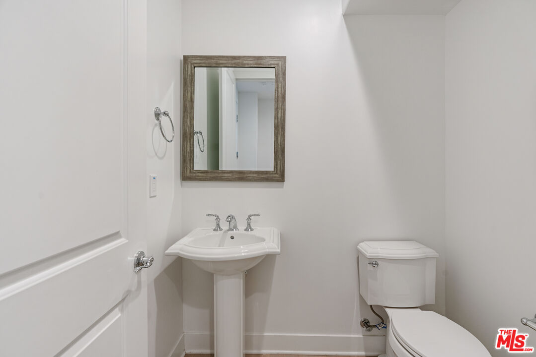 20618 West Wood Rose Court Porter Ranch, CA 91326 - Photo 20 of 44 a bathroom with a toilet sink and mirror