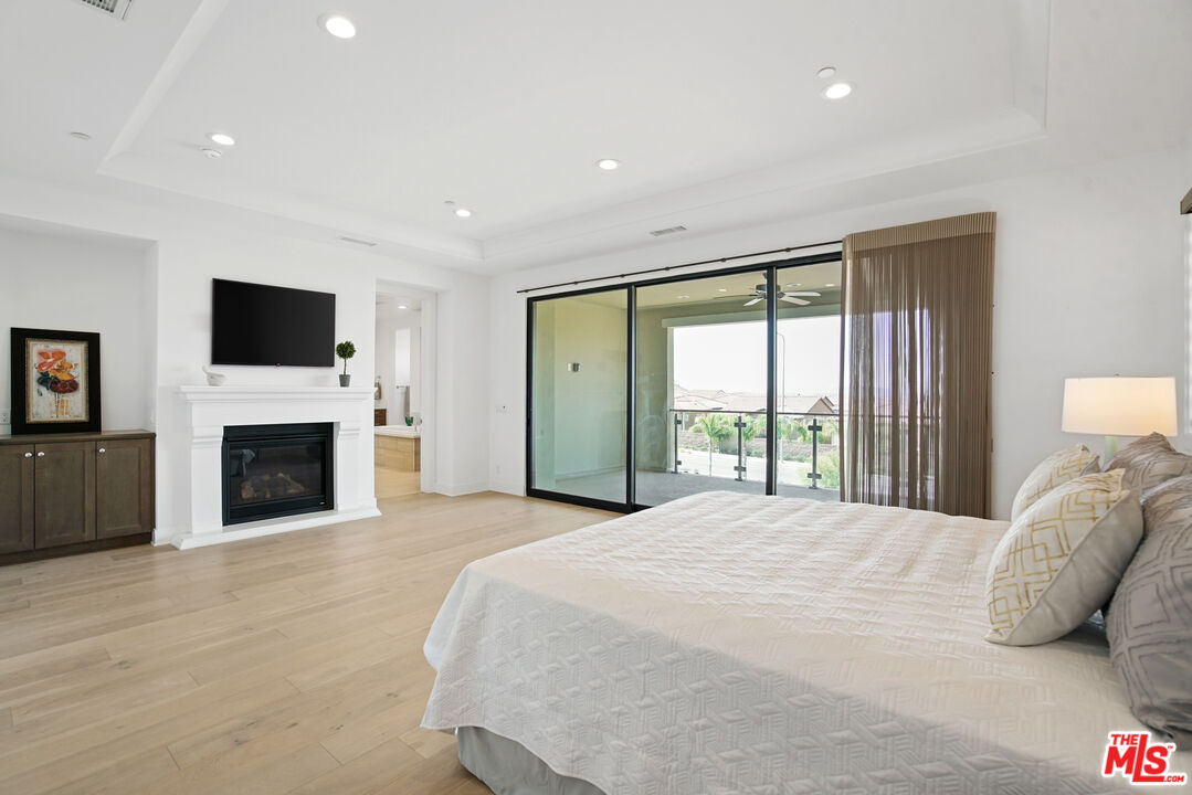 20618 West Wood Rose Court Porter Ranch, CA 91326 - Photo 24 of 44 a spacious bedroom with a large bed and a flat screen tv