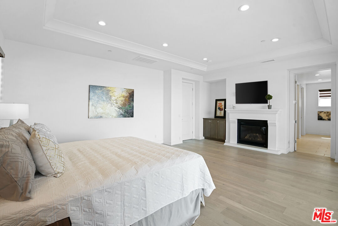 20618 West Wood Rose Court Porter Ranch, CA 91326 - Photo 25 of 44 a spacious bedroom with a bed and a fireplace