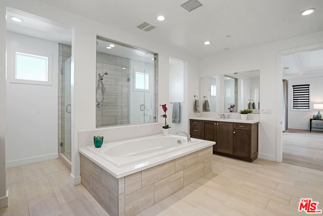 20618 West Wood Rose Court Porter Ranch, CA 91326 - Photo 27 of 44 a spacious bathroom with a tub sink and mirror
