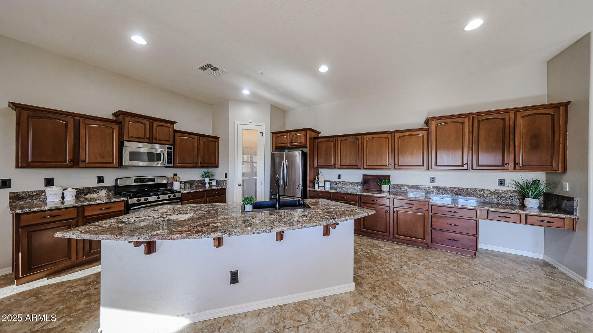 18391 Verdin Road Goodyear, AZ 85338 - Photo 18 of 94 a kitchen with stainless steel appliances granite countertop a stove top oven a sink dishwasher a refrigerator and a oven
