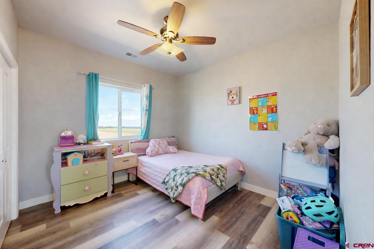 3728 Ruth Lane Delta, CO 81416 - Photo 18 of 34 a bedroom with a bed and a chandelier