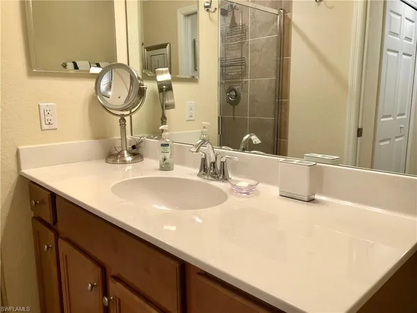 a bathroom with a granite countertop sink and a mirror
