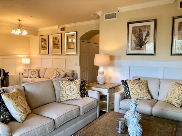 a living room with furniture and painting on the wall