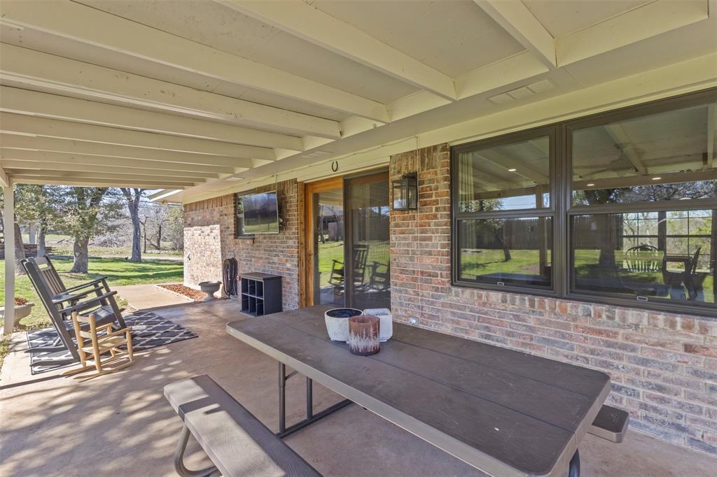 3009 Ranch House Road Willow Park, TX 76087 - Photo 34 of 40 a view of a patio with table and chairs potted plants with floor to ceiling window
