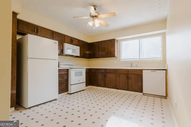 a kitchen with granite countertop a refrigerator and a sink