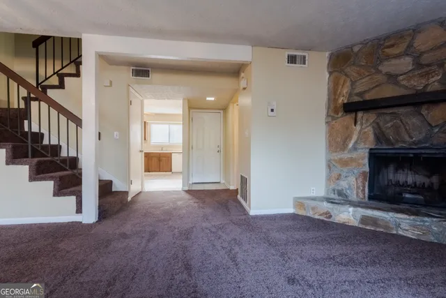 a view of a livingroom with wooden floor and a fireplace