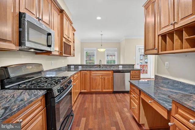 a kitchen with stainless steel appliances granite countertop a stove a sink and a microwave
