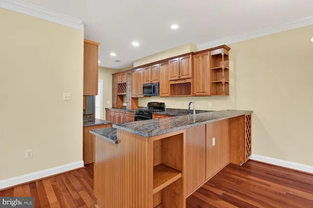 a kitchen with stainless steel appliances granite countertop a sink stove and cabinets