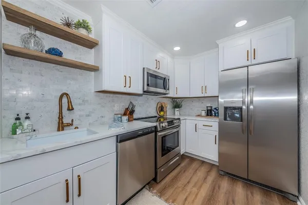a kitchen with stainless steel appliances granite countertop a refrigerator sink and microwave