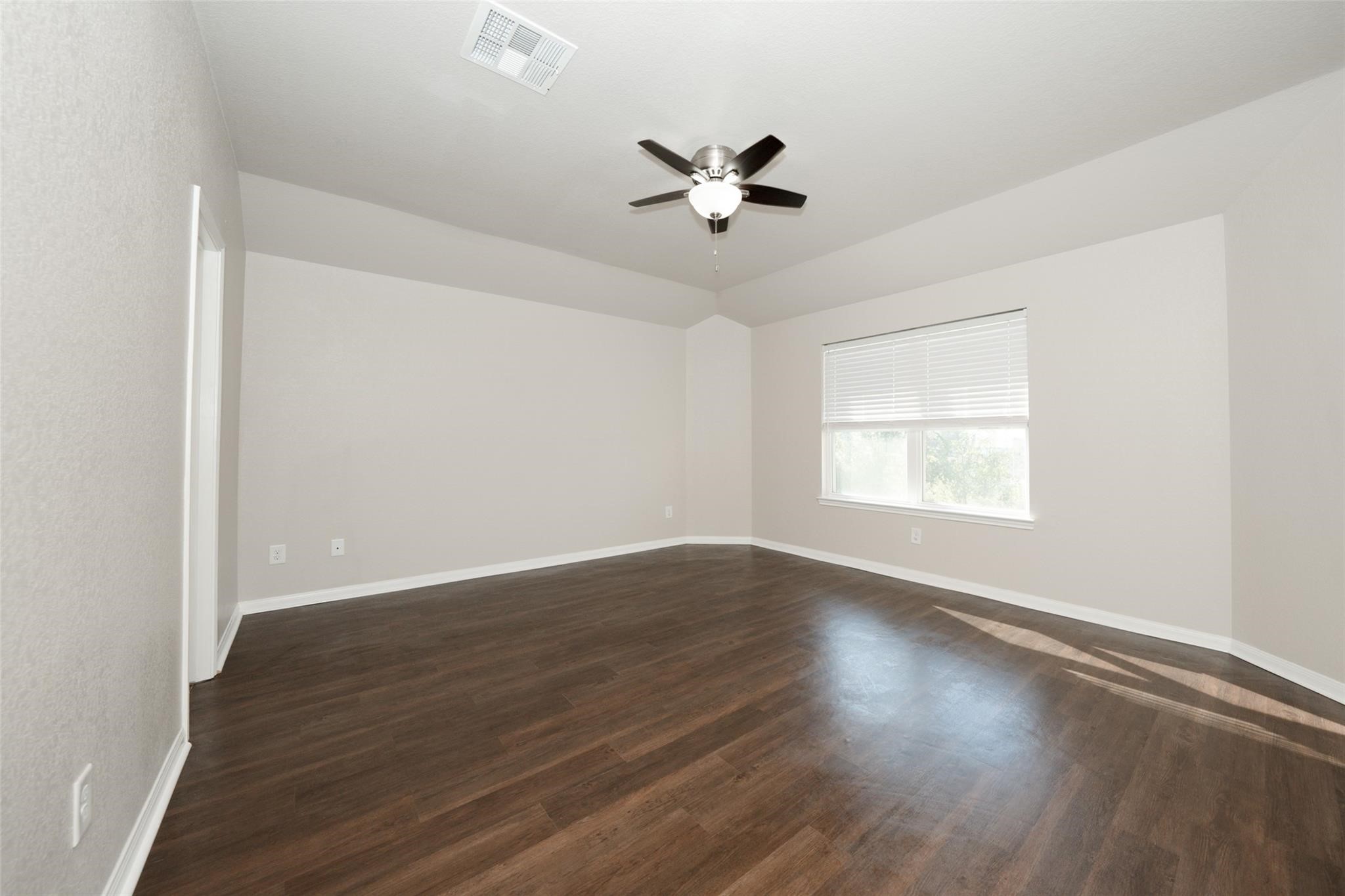 18834 Lansdowne Stream Path Katy, TX 77449 - Photo 12 of 21 an empty room with wooden floor fan and windows