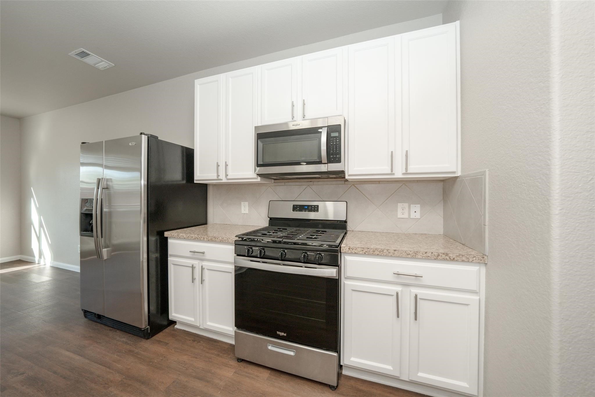 18834 Lansdowne Stream Path Katy, TX 77449 - Photo 5 of 21 a kitchen with stainless steel appliances white cabinets and a stove top oven
