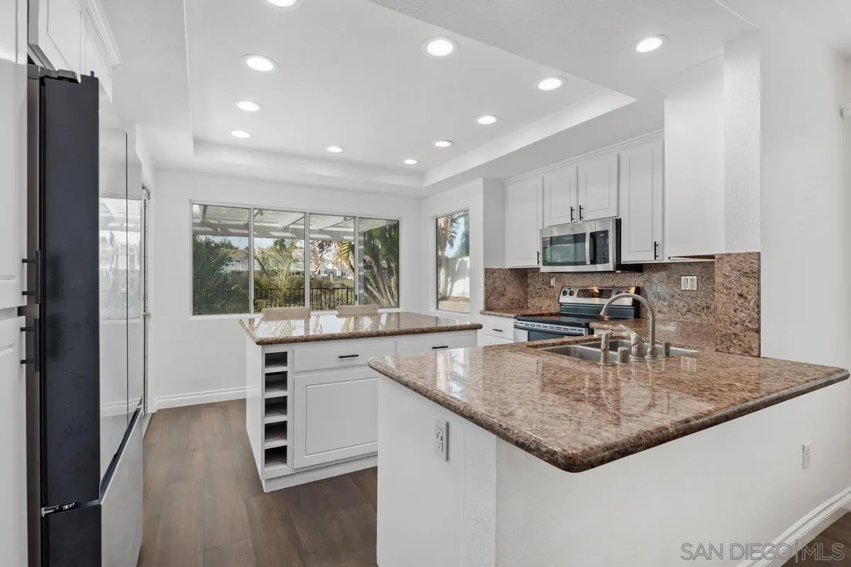 14680 Carmel Ridge Road San Diego, CA 92128 - Photo 13 of 33 a kitchen with kitchen island granite countertop a sink a counter top space appliances and cabinets