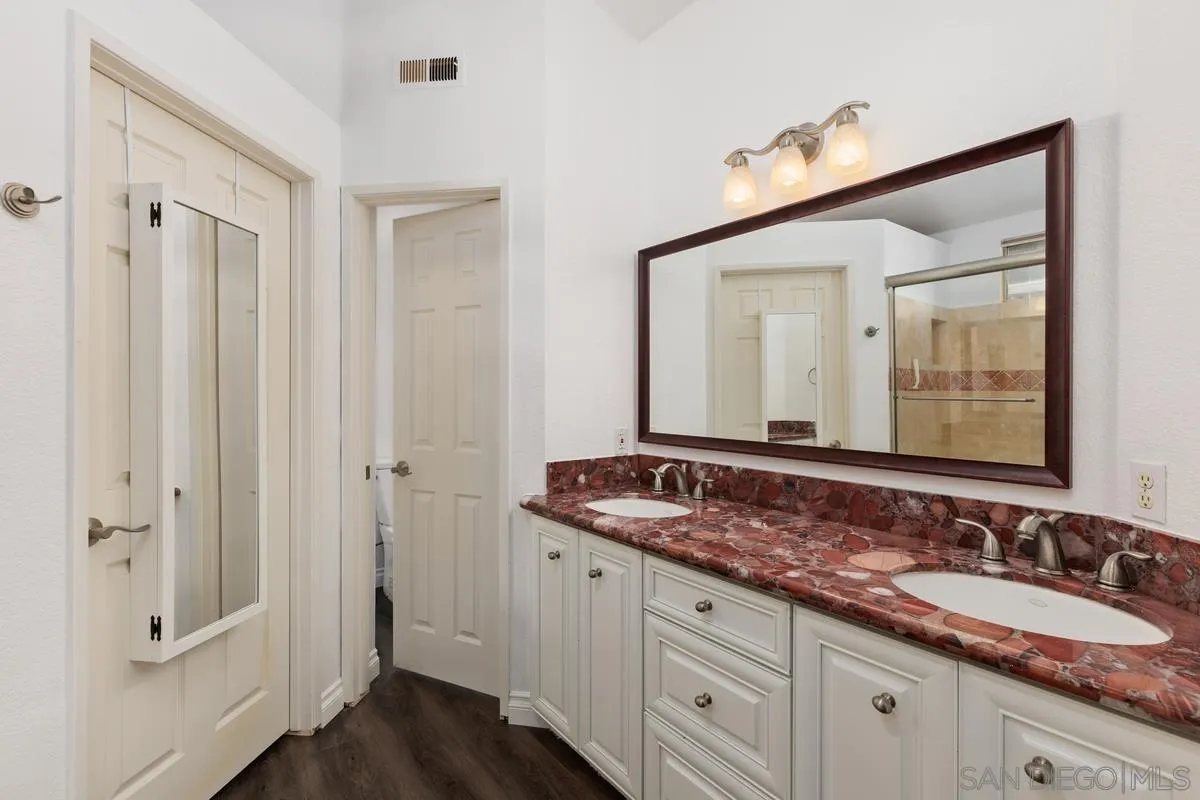 14680 Carmel Ridge Road San Diego, CA 92128 - Photo 21 of 33 a bathroom with a granite countertop sink and a mirror