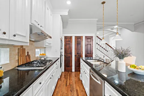 a kitchen with stainless steel appliances granite countertop a sink stove and refrigerator