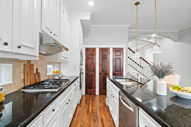 a kitchen with stainless steel appliances granite countertop a sink stove and refrigerator