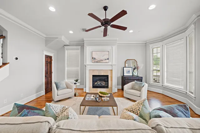 a living room with furniture a fireplace and a large window