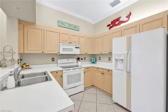a kitchen with white cabinets and white appliances