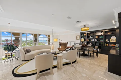 a living room with furniture kitchen view and a large window