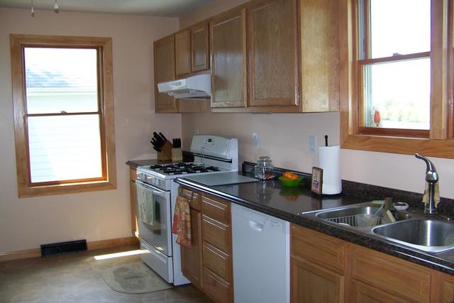 4265 North 3350 E Road Chatsworth, IL 60921 - Photo 3 of 22 a kitchen with granite countertop a sink a stove and cabinets