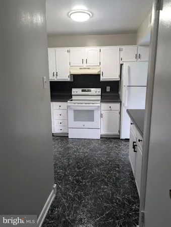 a kitchen with white cabinets and white appliances