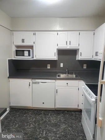 a kitchen with granite countertop white cabinets and stainless steel appliances