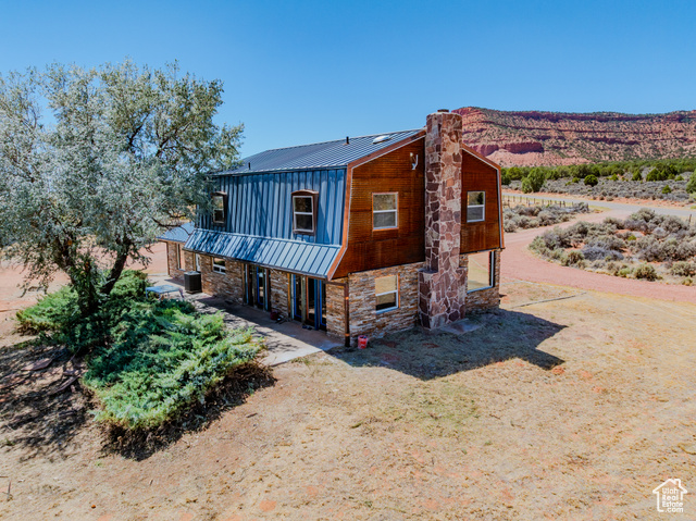 6178 East Zion Road Kanab, UT 84741 - Photo 43 of 48 View of front of home with a standing seam roof, stone siding, a metal roof, and a chimney