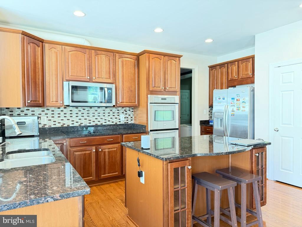 9804 Anvil Court Perry Hall, MD 21128 - Photo 6 of 21 a kitchen with stainless steel appliances granite countertop a sink and a refrigerator