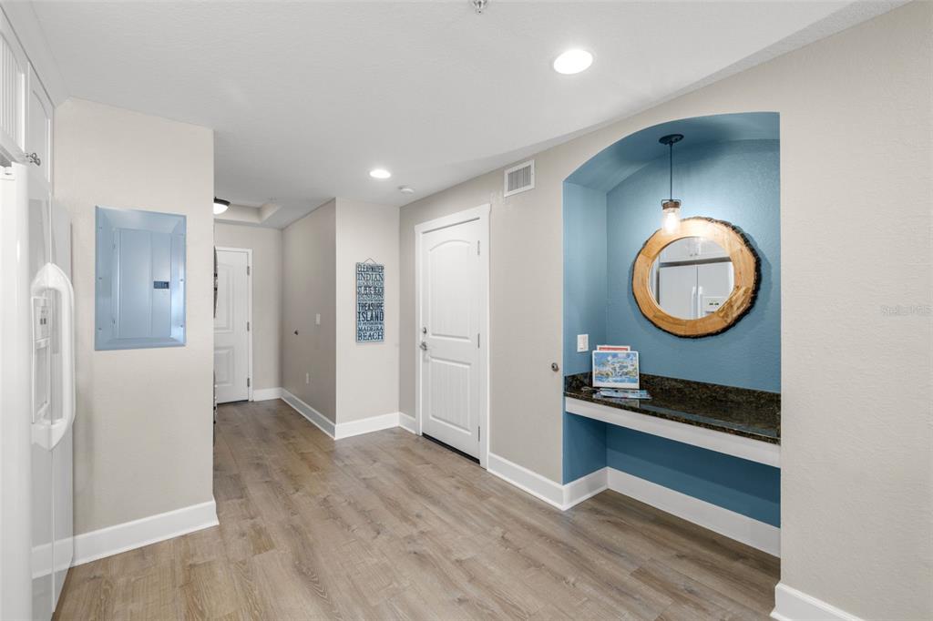 399 2nd Street, Unit 216 Indian Rocks Beach, FL 33785 - Photo 11 of 45 a view of a hallway with entryway wooden floor and cabinet