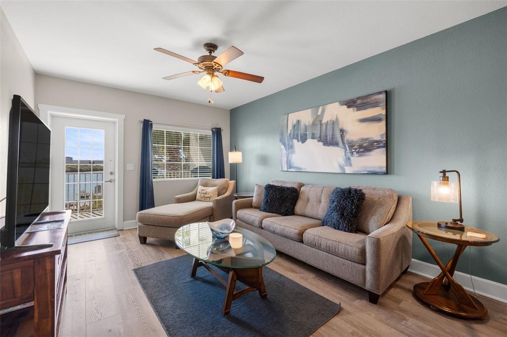 399 2nd Street, Unit 216 Indian Rocks Beach, FL 33785 - Photo 17 of 45 a living room with furniture a lamp and a flat screen tv